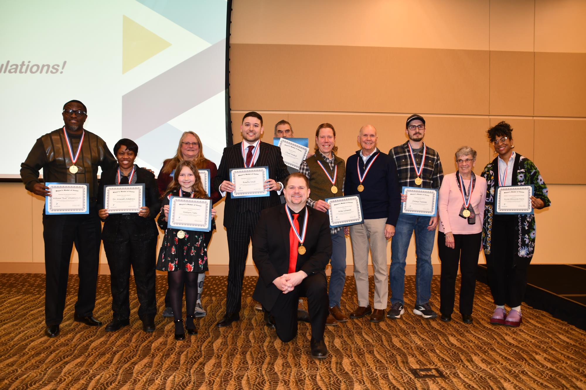 A group of people standing together holding award certificates.
